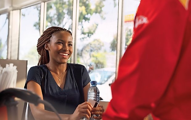 Female customer smiling at a Shell retail station.