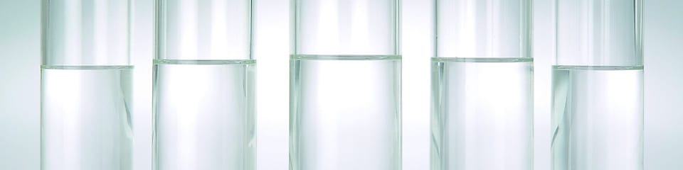Rangée de cinq béchers chacun rempli d'un liquide transparent