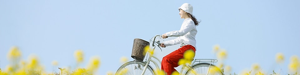 Une jeune femme fait une promenade à vélo dans un champ en été